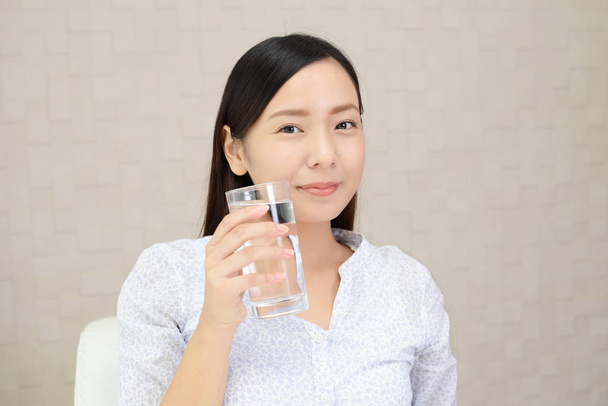 The young woman drinking a glass of water - Photo, Image