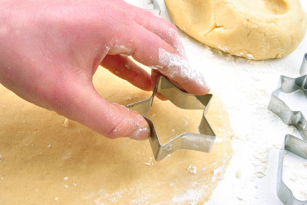 Christmas cookie is cut out of dough - Foto, Bild