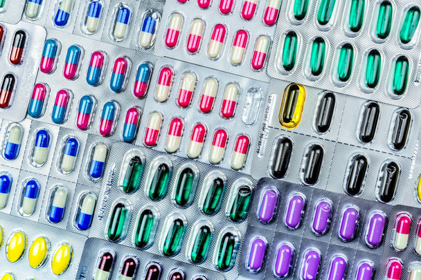 Kleurrijke van tabletten en capsules pil in blisterverpakking geregeld met prachtig patroon met flare licht. Concept van de farmaceutische industrie. Apotheek drogisterij. Antibiotica resistentie. Defecte. - Foto, afbeelding