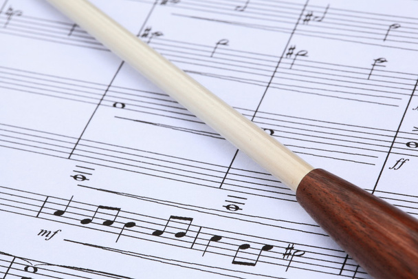 Baton de chef d'orchestre sur partition musicale
 - Photo, image
