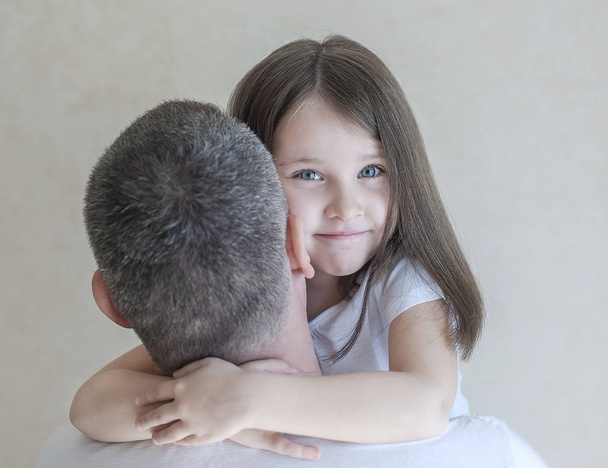 Portrait of cute little girl held in father's arms. Happy loving family. Father and his daughter child girl playing hugging. Cute baby and daddy. Concept of Father day. Family holiday and togetherness - Фото, зображення