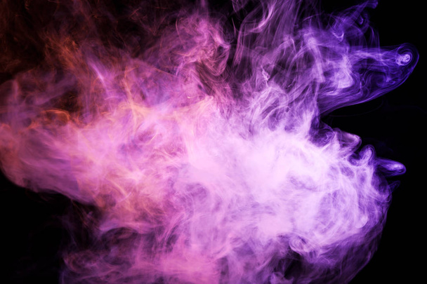 Dichter, mehrfarbiger Rauch in rosa und lila Farben auf schwarzem, isoliertem Hintergrund. Hintergrund der Rauchschwaden - Foto, Bild
