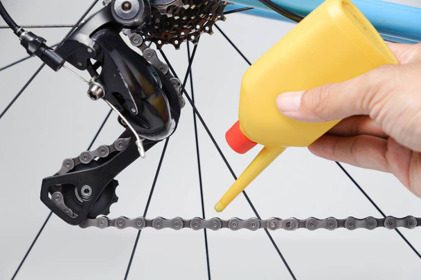 Mécanicien huilant chaîne de bicyclette et engrenages avec huile
. - Photo, image
