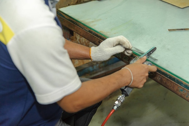 Arbeiter mit handlichem Luftbandschleifer. pneumatische Bandschleifmaschine - Foto, Bild