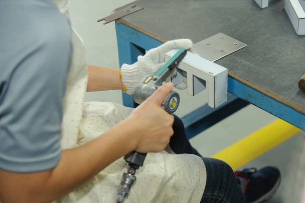 Arbeiter mit handlichem Luftbandschleifer. pneumatische Bandschleifmaschine - Foto, Bild