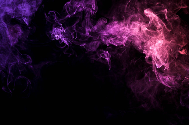 Fumaça multicolorida densa de cores rosa, azul e roxo em um fundo isolado preto
.  - Foto, Imagem