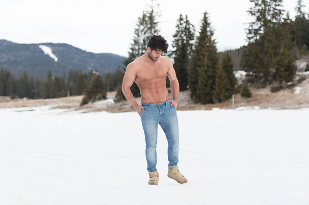 Handsome Young Model Standing Strong Outdoors and Flexing Muscles - Muscular Athletic Bodybuilder Man Posing - a Place for Your Text - Fotografie, Obrázek