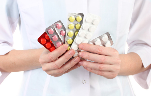 Крупним планом жінка-лікар рука тримає таблетки, ізольовані на білому
 - Фото, зображення