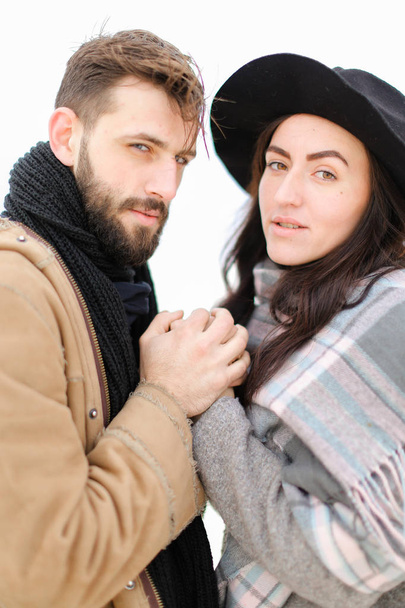 Porträt eines glücklichen Paares mit Schal und Mütze vor weißem Hintergrund. - Foto, Bild