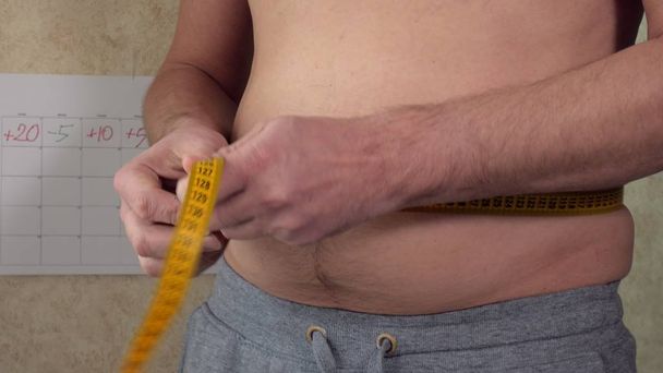 Un hombre gordo mide su cintura, una gran barriga de cerveza, un estilo de vida saludable
 - Foto, Imagen