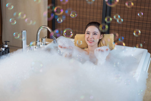 bela mulher toma banho de espuma e jogando na banheira
 - Foto, Imagem