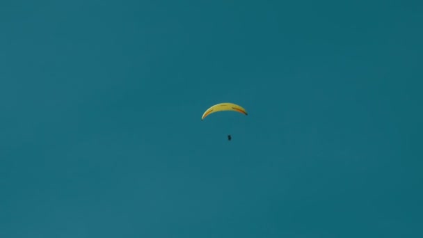 Σιλουέτα του κίτρινο αλεξίπτωτο που φέρουν ενάντια στον ουρανό - Πλάνα, βίντεο