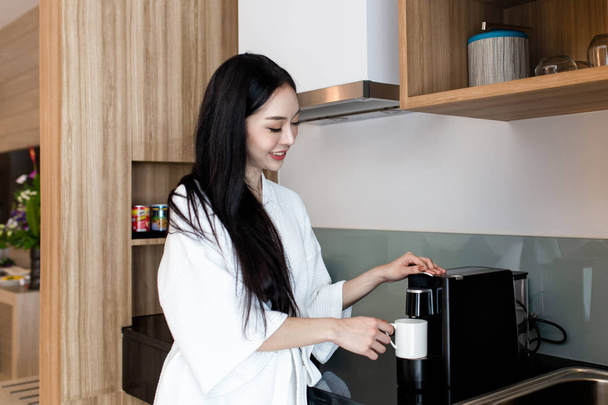 Beautiful asian woman making coffee for breakfast in the kitchen at home - Photo, image