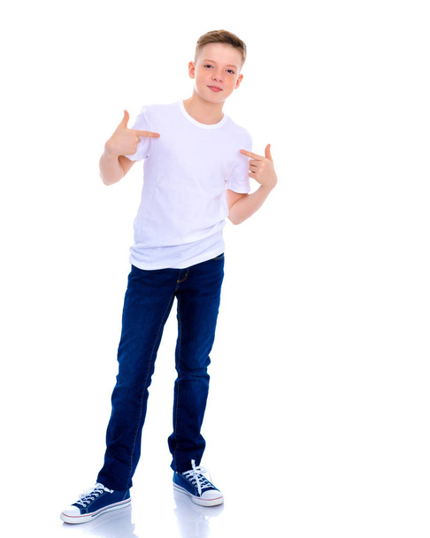 A school boy points to his white T-shirt. - Zdjęcie, obraz