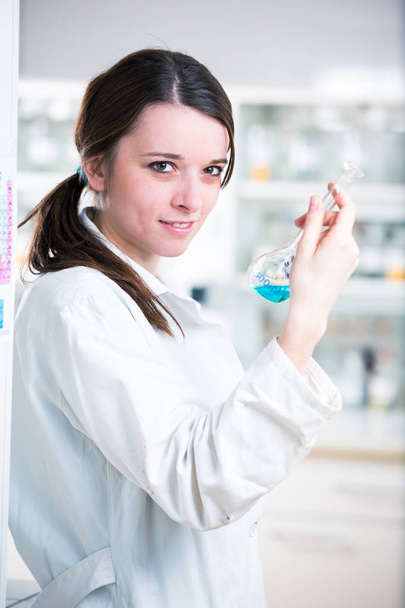 Portrait of a female researcher/chemistry student carrying out research in a chemistry lab (color toned image; shallow DOF) - Фото, изображение