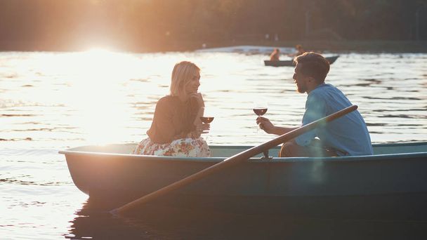 Jeune couple dans un bateau au coucher du soleil
 - Photo, image