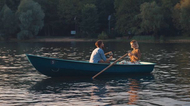 Νεαρό ζευγάρι σε μια βάρκα για διακοπές - Φωτογραφία, εικόνα