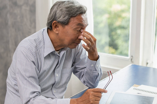 Ázsiai idős stressz fáradt és orra gazdaság szenved sinus fájdalom fáradtság-a kemény munka. - Fotó, kép