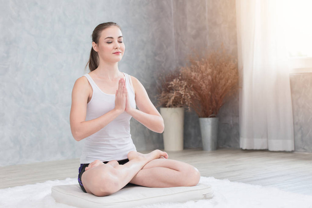 Méditation de yoga à la maison. femme saine assis concentration mains ensemble à la poitrine paix dans l'âme et l'esprit concept
 - Photo, image
