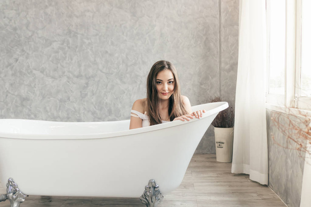 cute teen woman smiling waiting in the bathtub bathroom - Photo, Image