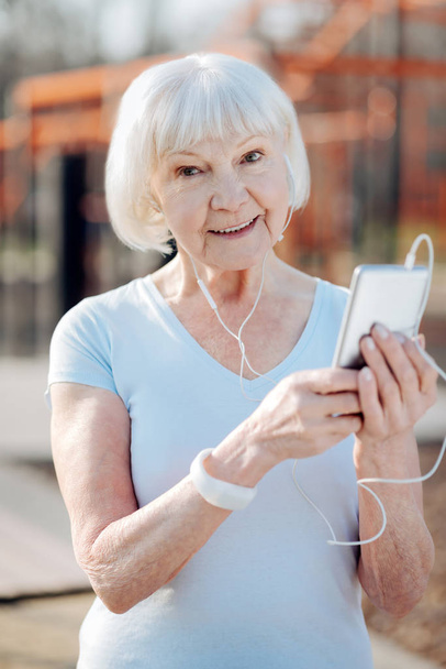 Gleeful old woman listening to music - Φωτογραφία, εικόνα