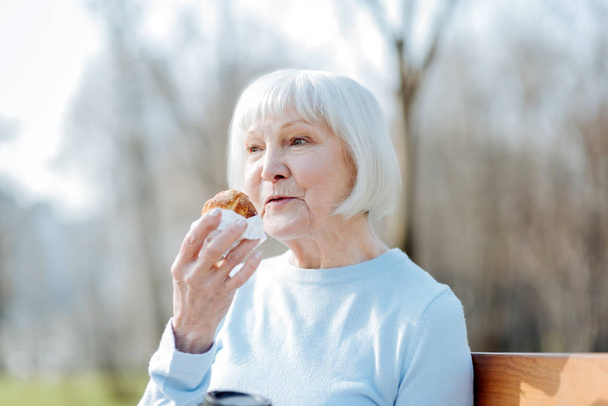 Mujer encantada disfrutando de su galleta
 - Foto, imagen