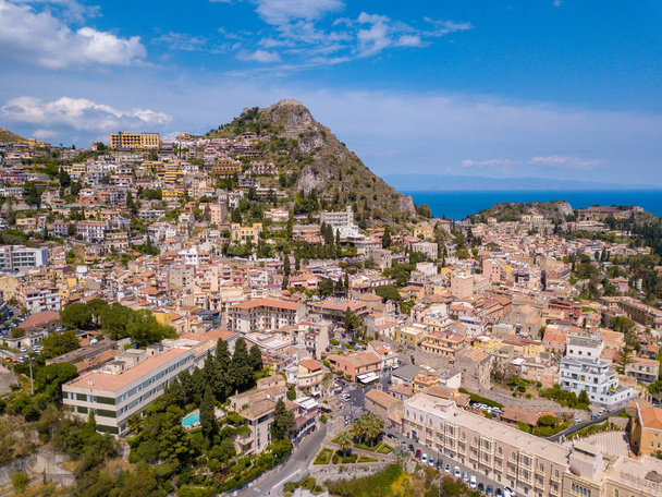 Aerial view of the Duomo in most popular Sicilian resort Taormina. Townscape of Taormina with cathedral, square and the hill with other buildings. - Photo, image