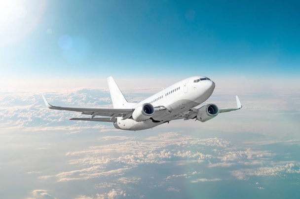Matkustaja valkoinen lentokone lentää sinisellä taivaalla kirkas aurinko
 - Valokuva, kuva