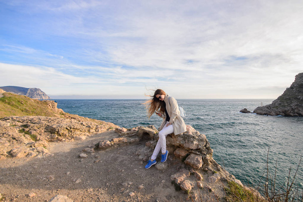Дівчина з довгим волоссям фотографує себе біля моря
 - Фото, зображення