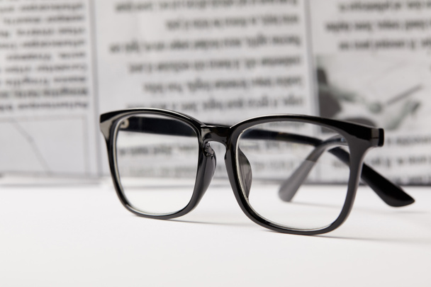 Selektive Fokussierung von Brille und Zeitung auf den Hintergrund - Foto, Bild