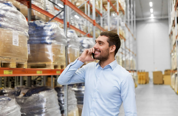 businessman calling on smartphone at warehouse - Foto, Imagem