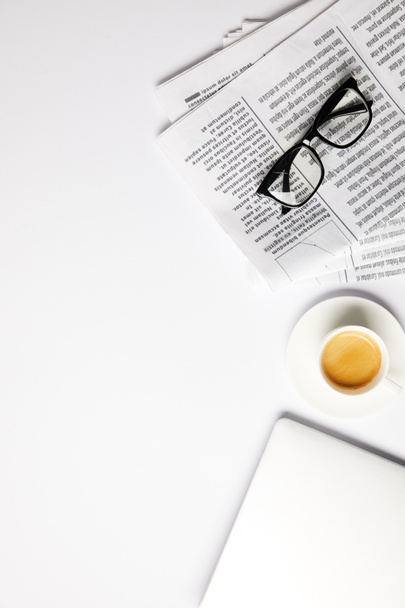 flat lay with eyeglasses, coffee, laptop and newspapers, on white with copy space - Photo, Image
