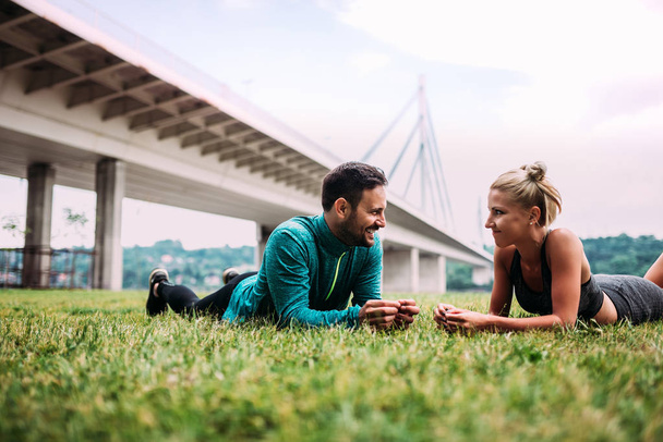 Fit couple lying on grass and talking after workout. - Fotoğraf, Görsel
