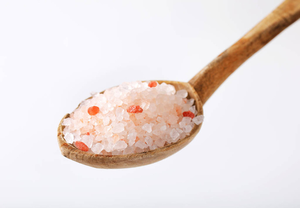 白い背景の粗粒ヒマラヤ塩のスプーン - 写真・画像