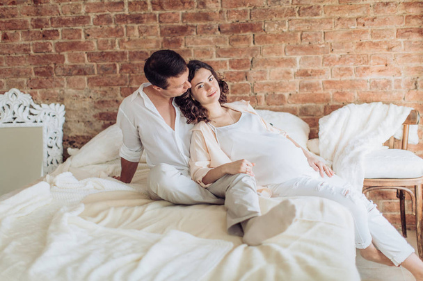 Beautiful pregnant woman and her husband is in their bedroom - Foto, immagini