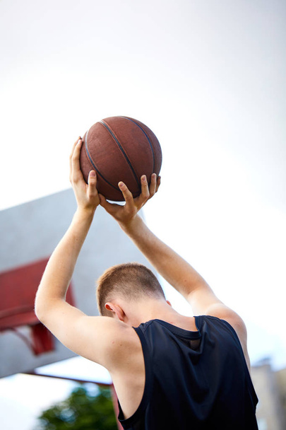 man holding ball while playing basketball outdoor - Zdjęcie, obraz