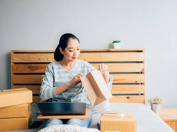 Asian woman ready to ship the products of her online store to the customer. Concept of work at home online business. - Foto, immagini