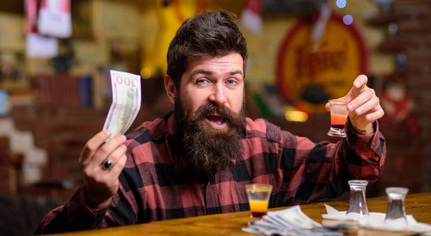 Hipster holds money, cash to buy more alcohol. - Foto, imagen