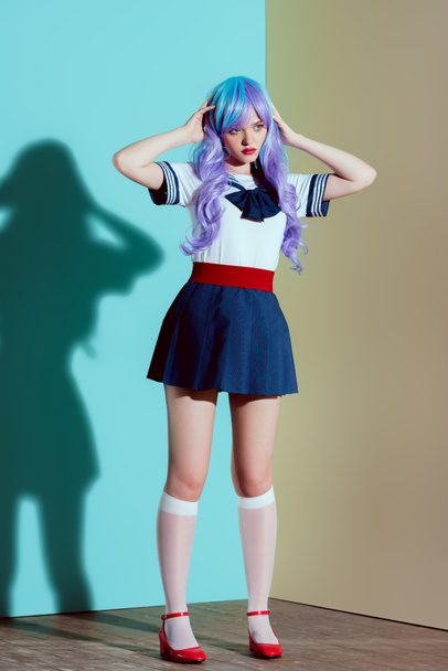 full length view of beautiful stylish girl in bright wig, skirt and stockings posing in studio - 写真・画像
