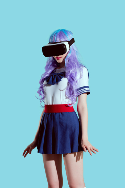menina elegante em peruca brilhante usando fone de ouvido realidade virtual isolado em azul
  - Foto, Imagem