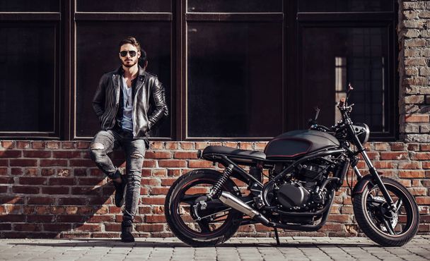 Handsome bearded biker with classic style black motorcycle. Cafe racer. - Φωτογραφία, εικόνα