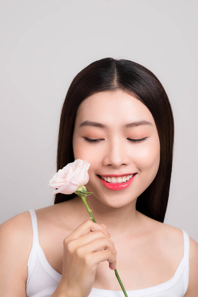 portrait of beautiful asian woman holding pink rose flower - Foto, afbeelding