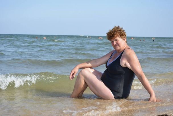 夏には、海、大人の巻き髪女は歩いている水着姿でビーチに. - 写真・画像