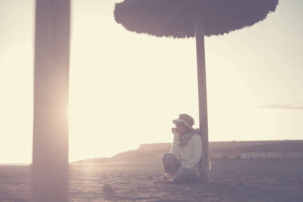 solitário bela meia-idade fêmea sentar-se na praia com luz do sol incrível no fundo. Tenerife lugar cênico para férias. tempo de lazer de verão para mulher independente desfrutar de liberdade
 - Foto, Imagem
