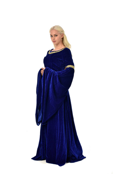 po celé délce portrét hezká blondýnka dáma na sobě modré fantasy středověké šaty. představovat stojící na bílém pozadí. - Fotografie, Obrázek