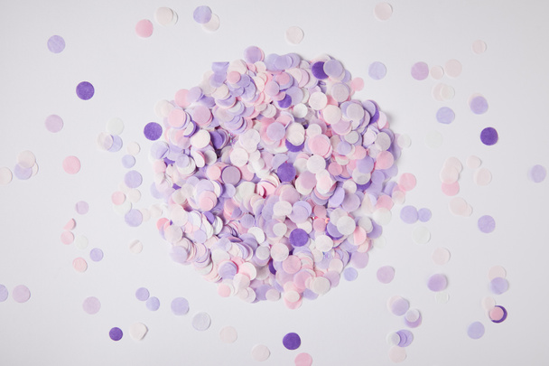 vue de dessus de pile de morceaux de confettis violets sur la surface blanche
 - Photo, image