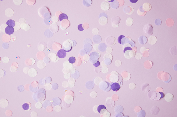 top view of scattered violet confetti pieces on surface - Photo, Image