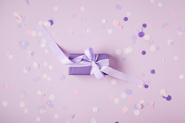 vue de dessus d'une boîte cadeau violette et des morceaux de confettis sur la surface
 - Photo, image