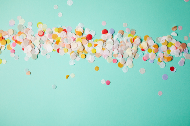 top view of confetti pieces on turquoise surface - 写真・画像