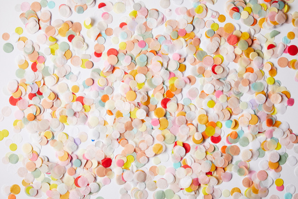 top view of colored confetti pieces on white tabletop - Φωτογραφία, εικόνα